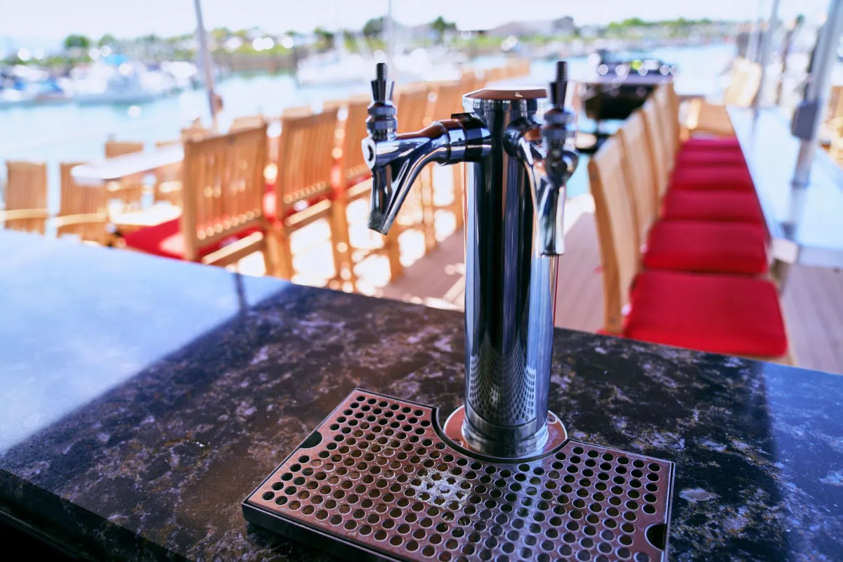 Beer tap on the boat's bar overlooking the marina at twilight